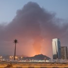 Una alta columna de humo negro se eleva tras una explosión en la zona industrial de Emiratos