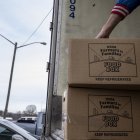 Un voluntario apila cajas de alimentos del programa "Agricultores a Familias" del USDA