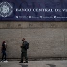 Varias personas caminan frente a la fachada principal del Banco Central de Venezuela en Caracas