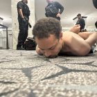 This image released by US President Donald Trump via his Truth Social account (@realDonaldTrump) shows a person he claims to be the alleged suspect in the shooting incident at the White House Correspondents Dinner on the ground after being apprehended on April 25, 2026. US Secret Service agents bundled Donald Trump from the stage as shots rang out Saturday evening at a media gala, in what the president later described as an attack by a "would-be assassin." Armed guards opened fire at the gunman who charged through security screening just outside the ballroom of the hotel, where Trump, First Lady Melania Trump, many senior government officials and hundreds of other black-tie guests had gathered. (Photo by @REALDONALDTRUMP / TRUTH SOCIAL / AFP) / RESTRICTED TO EDITORIAL USE - MANDATORY CREDIT "AFP PHOTO /  @REALDONALDTRUMP - TRUTH SOCIAL " - HANDOUT - NO MARKETING NO ADVERTISING CAMPAIGNS - DISTRIBUTED AS A SERVICE TO CLIENTS