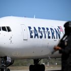 Un avión estadounidense carretea en el aeropuerto Simón Bolívar de Maiquetía. En primer plano, un funcionario de la Policía Nacional Bolivariana.