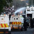 La policía utiliza un cañón de agua mientras bloquea el paso a los manifestantes en Glengormley, al norte de Belfast