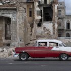 Un coche viejo pasa junto a los escombros de una casa en La Habana (Archivo)
