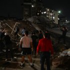 Personas de pie junto a un edificio derrumbado tras un terremoto en Caracas el 24 de junio de 2026.