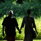 Una pareja de adultos mayores camina por un parque público (Archivo)