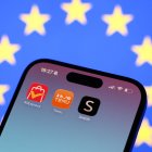 Una bandera de la Unión Europea detrás de las aplicaciones de AliExpress, Temu y Shein