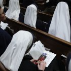 A nun looks through the program of the Solemn Vespers evening prayer at St. Patrick's Cathedral in New York