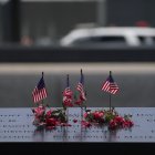 Banderas estadounidenses y flores adornan el estanque conmemorativo del Monumento Nacional del 11 de Septiembre