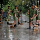 Reclutas cubanos barren una calle de La Habana en 2008 tras el paso del devastador huracán Ike