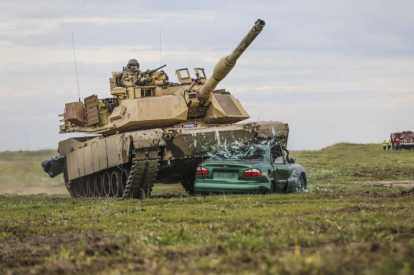An M1 Abrams tank crushes a car during a drill in Poland, 2019.